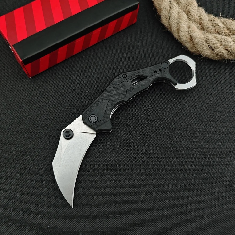Ustensile de Cuisine Ergonomique Couteau de Poche Pliable sur fond noir avec une boite rouge et une corde